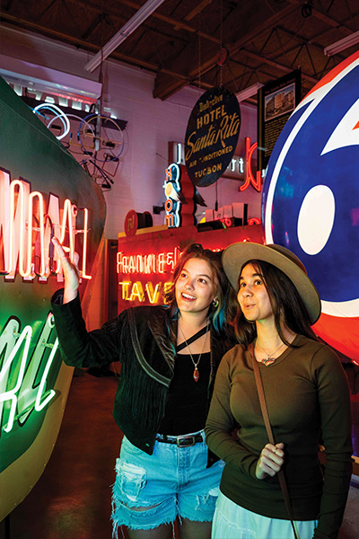 Two girls look at vintage neon signs inside the Ignite Sign Art Museum in Tucson