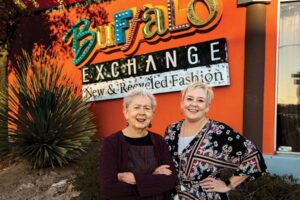 Two women stand in front of the Buffalo Exchange store.